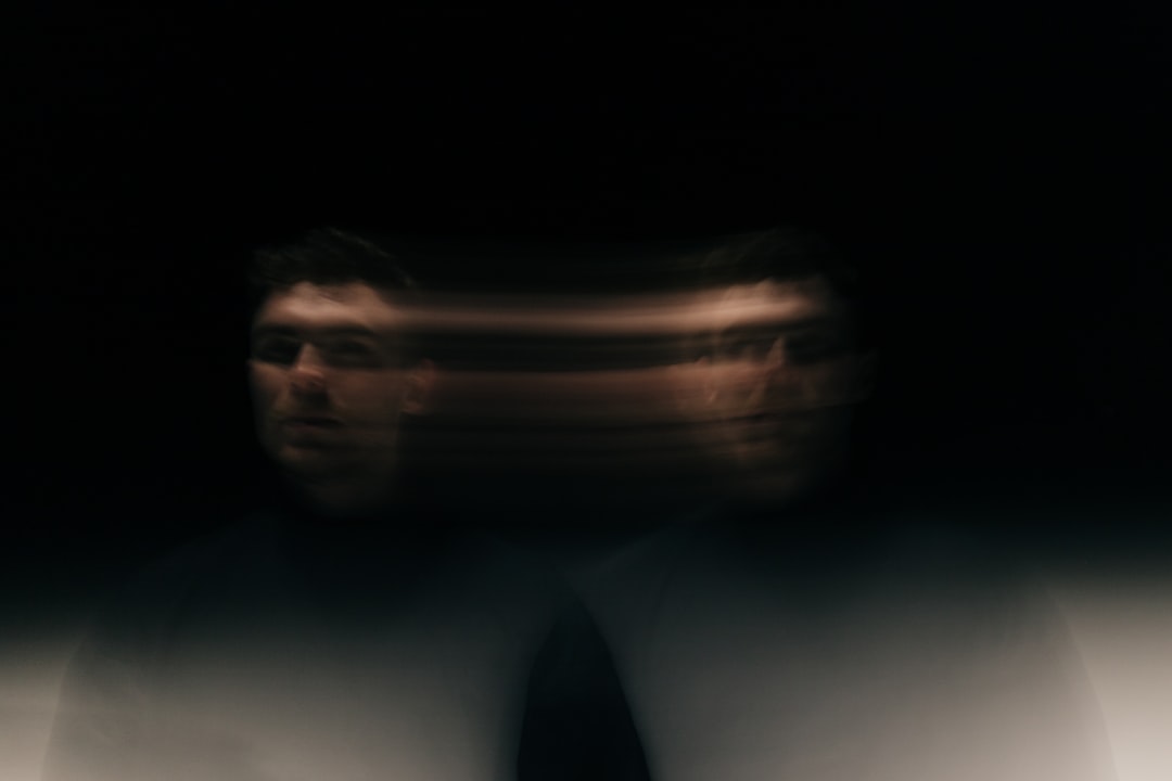 A blurry image of a man in a white shirt
