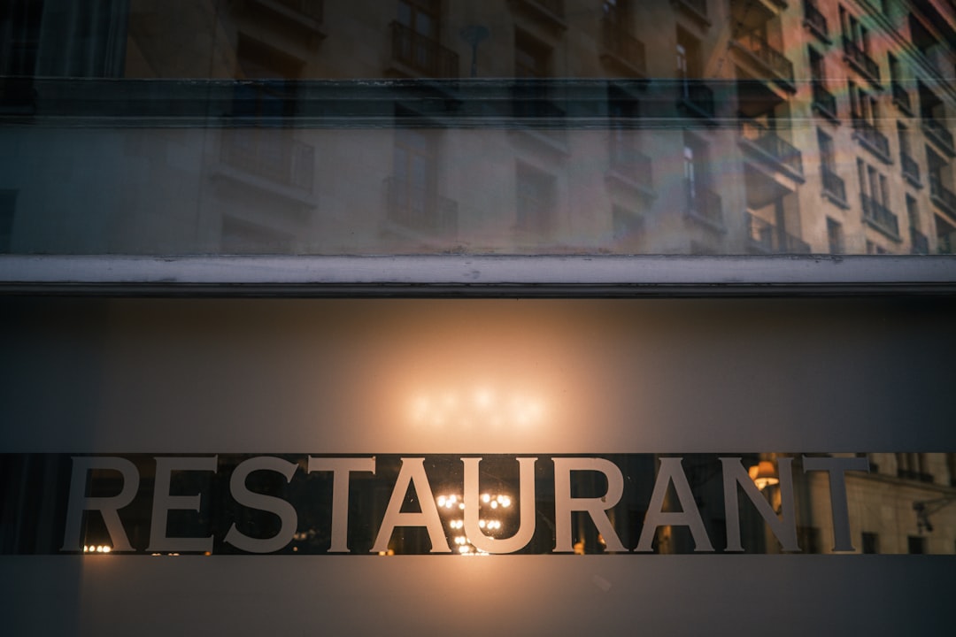 Restaurant sign illuminated at night with building reflection.